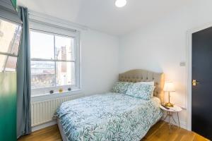 a bedroom with a bed and a window at Indigo City Apartment in London