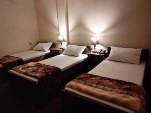 two beds in a room with two lamps on them at Canal view hotel in Faisalabad