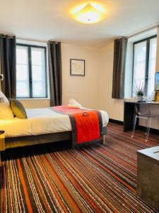 una camera d'albergo con un letto e un tappeto di Au Coeur Des Bulles a Loches-sur-Ource