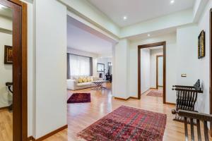 sala de estar con paredes blancas y suelo de madera. en Exclusive Apartment in Eur Lake, en Roma