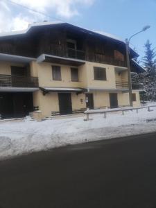 un edificio al lado de la carretera en la nieve en CASA ILARIA, en Faidello