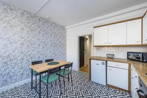a kitchen with a table and chairs in a room at Indigo City Apartment in London