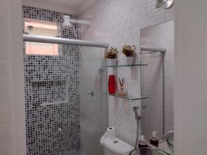 uma casa de banho com um chuveiro, um lavatório e um WC. em Flat Beach Selma em Porto de Galinhas