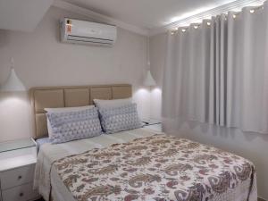 a white bedroom with a large bed with a blanket at Flat Beach Selma in Porto De Galinhas