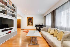 a living room with a white couch and a piano at Exclusive Apartment in Eur Lake in Rome