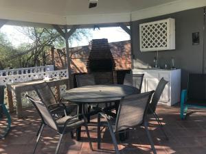 a table and chairs on a patio with an umbrella at Cheerful 4 bedroom home with pool and BBQ area with 5th bedroom option in Brownsville