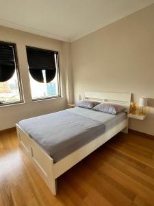 イスタンブールにあるYour home in istanbulのベッドルーム1室(白いベッド1台、窓2つ付)