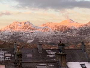 een uitzicht op de met sneeuw bedekte bergen vanuit een huis bij Cosy cottage in picturesque Snowdonia with stunning views of the Moelwyn mountains in Blaenau-Ffestiniog