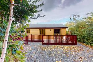 a small yellow house with a red fence at Chestnut Lodge, Summerhayes in Bridgwater