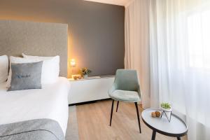 a hotel room with a bed and a chair at Select Hotel Maastricht in Maastricht