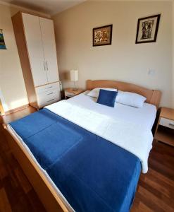 a bedroom with a large bed with a blue blanket at Apartment Vukica with free parking in Petrovac na Moru