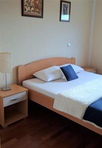 a bedroom with a bed and a night stand with a lamp at Apartment Vukica with free parking in Petrovac na Moru