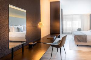 a hotel room with a bed and a desk with a mirror at Select Hotel Maastricht in Maastricht