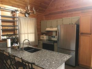 eine Küche mit Granitarbeitsplatte und Kühlschrank in der Unterkunft Smoky's Lakeside Den in Sevierville