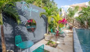 Turquoise Tulum Hotel في تولوم: فناء مع كراسي ومسبح