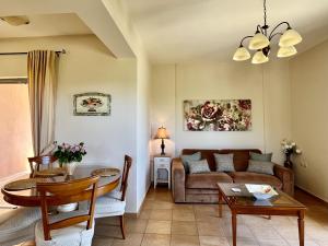een woonkamer met een bank en een tafel bij Villa Marianna in Lourdhata