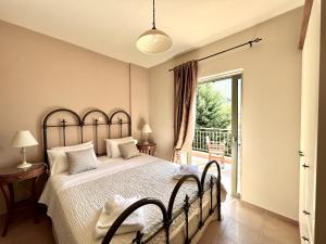 a bedroom with a large bed and a balcony at Villa Marianna in Lourdhata +35 photos