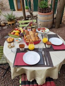 a table with plates of food and bread and orange juice at Mas Peu Del Causse in Thuir