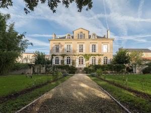 una grande casa con un vialetto davanti di Chambre d'hotes La maison de Maître a Fontenay-le-Comte