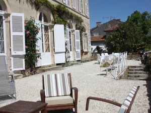 un gruppo di sedie e tavoli in un cortile di Chambre d'hotes La maison de Maître a Fontenay-le-Comte