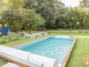 uma piscina num quintal com duas cadeiras de jardim em Chambre d'hotes La maison de Maître em Fontenay-le-Comte