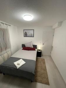 um quarto com uma cama grande e uma almofada vermelha em Appartment Relax&Easy em Karlsruhe