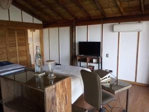 Zimmer mit einem Schreibtisch mit einem Stuhl und einer Flasche in der Unterkunft Zuzu Vichayito Casa para 9 con piscina in Los Órganos