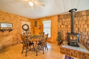 - une salle à manger avec une table et un poêle à bois dans l'établissement The Burgundy Cabin Iowa Retreat Pond and Fire Pit, à Spragueville