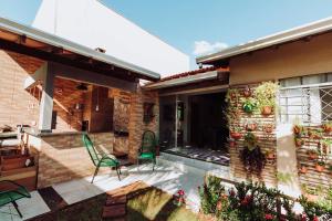 a patio of a house with a green chair at Casa c churrasq em Monte Castelo, Campo Grande-MS in Campo Grande