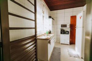 a small kitchen with a refrigerator and a sink at Casa c churrasq em Monte Castelo, Campo Grande-MS in Campo Grande