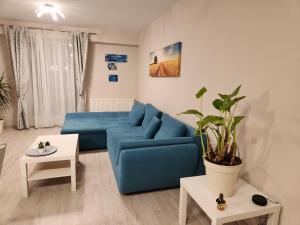 a living room with a blue couch and a table at Airport Apartment Otopeni in Otopeni