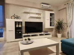 a living room with a tv and a couch and a table at Airport Apartment Otopeni in Otopeni