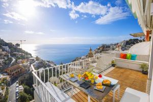 balcone con tavolo e vista sull'oceano di AMORE RENTALS - Casa Paradisea a Positano