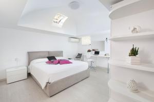 una camera bianca con letto e scrivania di AMORE RENTALS - Casa Paradisea a Positano