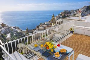 un tavolo su un balcone con vista sull'oceano di AMORE RENTALS - Casa Paradisea a Positano