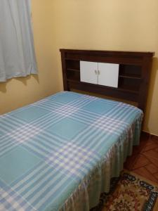 Cama en habitación con sábanas azules y blancas en Casa em Campos do Jordão, en Campos do Jordão