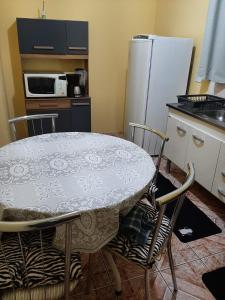 cocina con mesa, sillas y nevera en Casa em Campos do Jordão, en Campos do Jordão