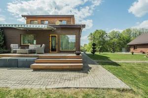 una casa con terraza y una casa en 3-bedroom villa surrounded by beautiful nature, en Vaišvydava