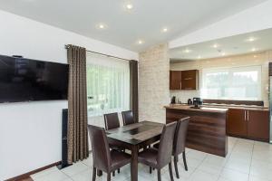 cocina con mesa y sillas y TV en 3-bedroom villa surrounded by beautiful nature, en Vaišvydava