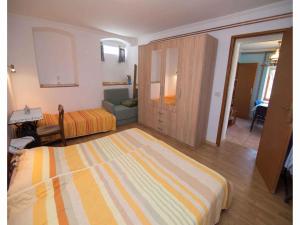 a bedroom with a bed and a couch in a room at Apartments in Veli Losinj 14928 in Veli Lošinj