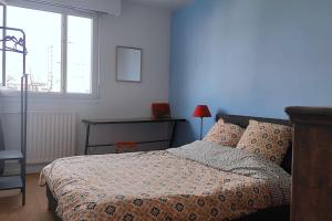 a bedroom with a bed and a desk and a window at Appt d'artiste - 3 ch - Parking in Rouen