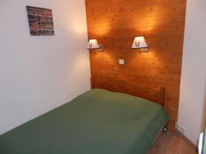 - une chambre avec un lit vert dans une pièce dotée de murs en bois dans l'établissement Appartement Avoriaz, 2 pièces, 4 personnes - FR-1-634-49, à Avoriaz
