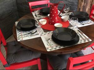 una mesa de madera con sillas rojas y placas y vasos negros en Appartement Avoriaz, 2 pièces, 5 personnes - FR-1-634-75, en Morzine