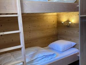 Etagenbett mit zwei weißen Kissen und einer Leiter in der Unterkunft Appartement Avoriaz, 2 pièces, 4 personnes - FR-1-634-76 in Morzine