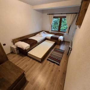 niewielka sypialnia z 2 łóżkami i oknem w obiekcie Планински перли, дом 1 w mieście Stoykite