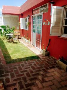 une maison rouge avec une cour et une terrasse dans l'établissement Casa Olivia, à Alta Gracia