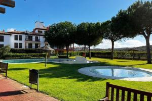a park with a bench and a swimming pool at Ayamonte Vista Esuri Golf - 12 min to Isla Canela in Huelva