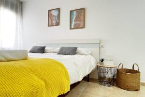 a bedroom with a large bed with a yellow blanket at Ayamonte Vista Esuri Golf - 12 min to Isla Canela in Huelva +14 photos