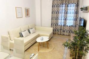 a living room with a white couch and a table at Ayamonte Vista Esuri Golf - 12 min to Isla Canela in Huelva