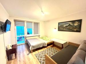 a living room with a bed and a couch at Willa Victoria in Szklarska Poręba